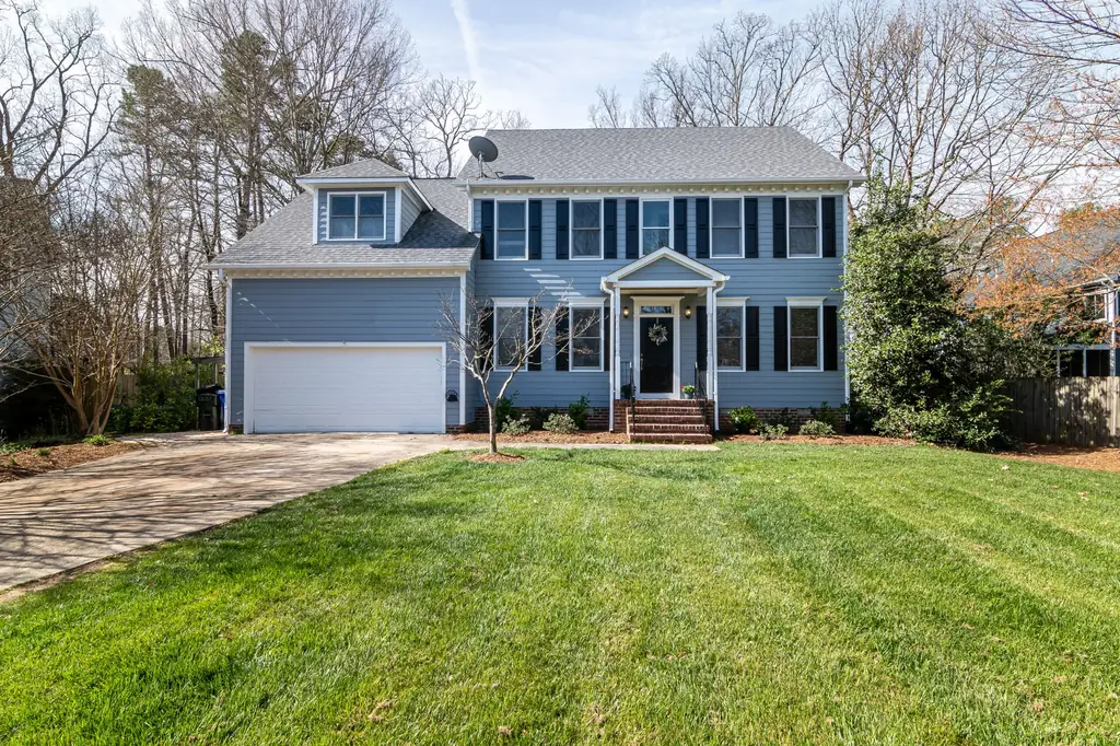 Two-story home with a dense, manicured front lawn